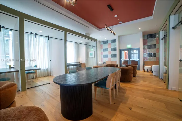 a living room with couches a table and chairs with wooden floor