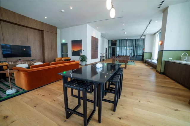 a kitchen with a table chairs a sink dishwasher refrigerator and cabinets