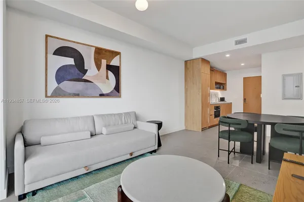 a living room with furniture a lamp and a floor to ceiling window