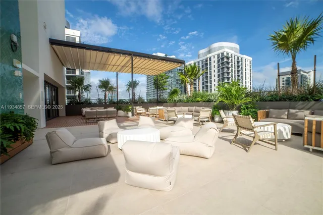 a view of a patio with couches and a table and chairs with potted plants
