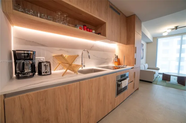 a kitchen with stainless steel appliances granite countertop a sink and wooden cabinets