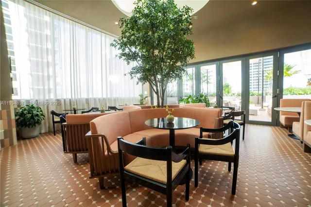 a dining room with furniture and a large window