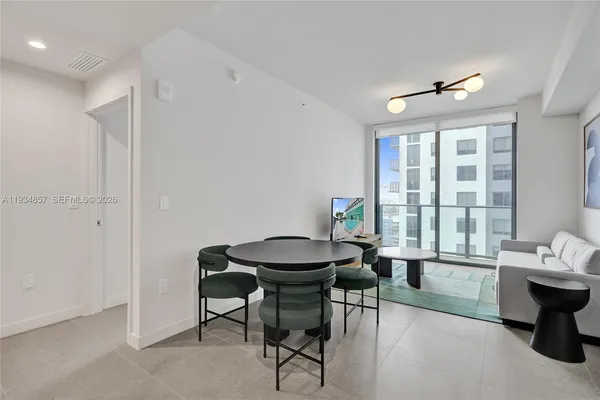 a living room with couches a table and chairs with wooden floor