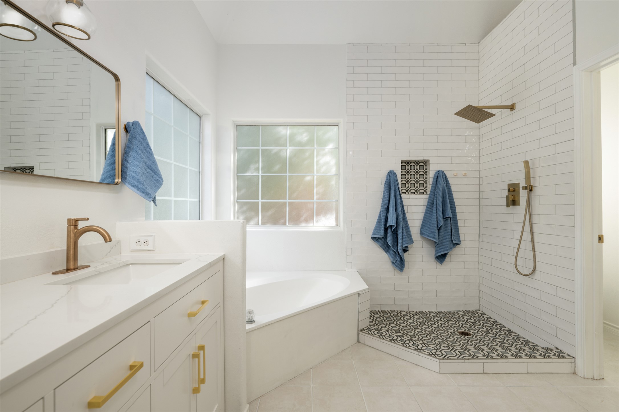 72 Crazy Cross Road Wimberley, TX 78676 - Photo 19 of 35 An open walk-in shower and corner soaking tub anchor this tiled primary bath.