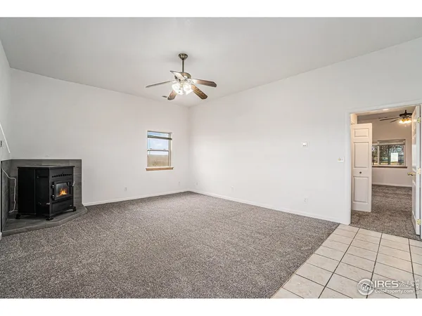 a view of empty room with a fireplace and fan