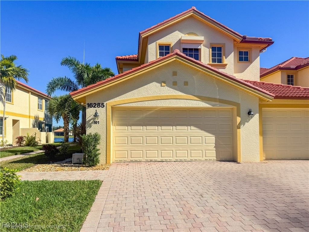 16285 Coco Hammock Way, Unit 101 Fort Myers, FL 33908 - Photo 1 of 50 a front view of a house with a yard
