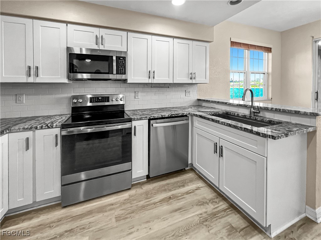 16285 Coco Hammock Way, Unit 101 Fort Myers, FL 33908 - Photo 11 of 50 a kitchen with granite countertop a sink and steel appliances