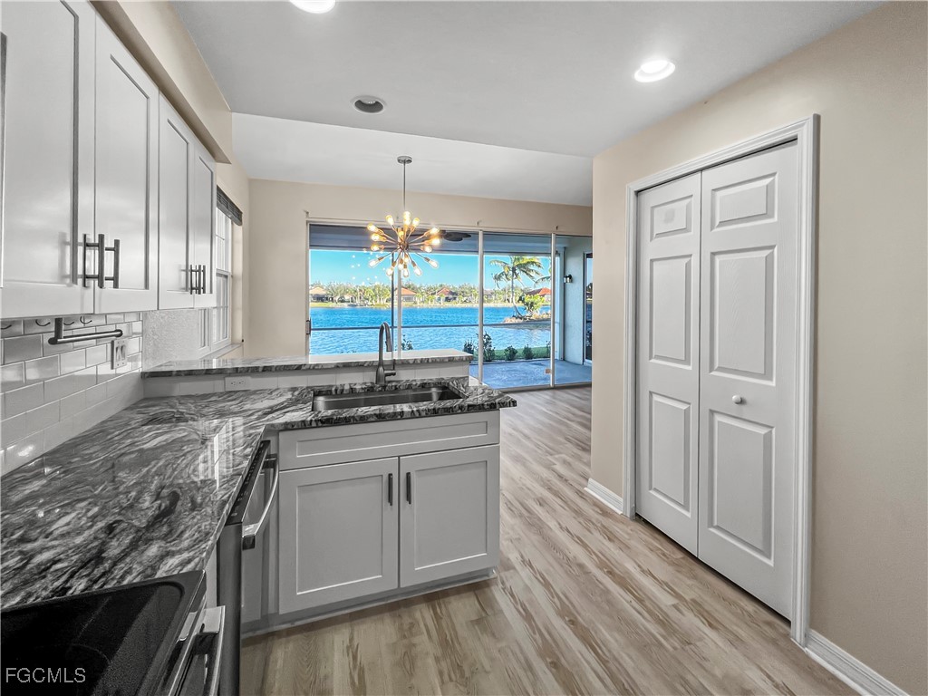 16285 Coco Hammock Way, Unit 101 Fort Myers, FL 33908 - Photo 12 of 50 a kitchen with stainless steel appliances granite countertop a stove and a sink