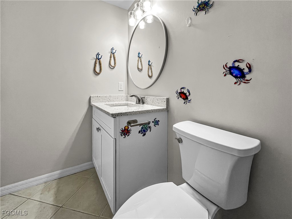 16285 Coco Hammock Way, Unit 101 Fort Myers, FL 33908 - Photo 17 of 50 a bathroom with a toilet sink vanity and mirror