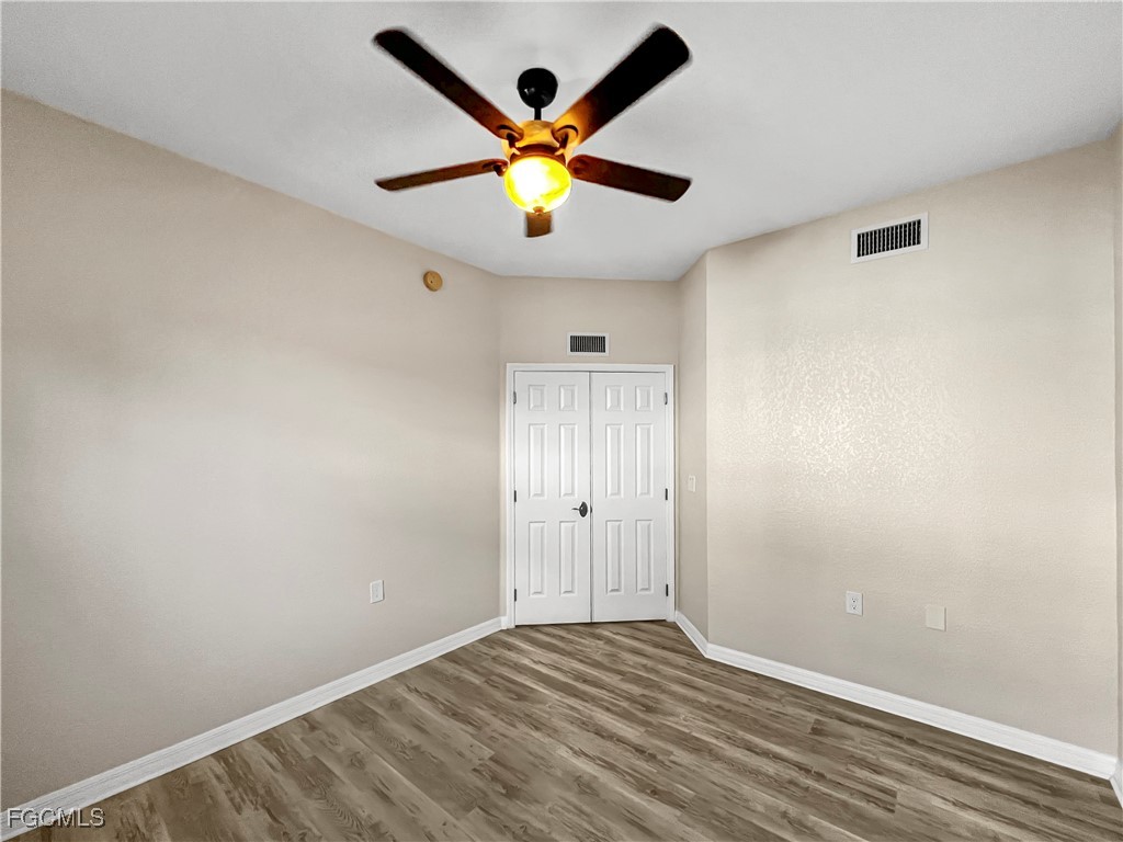 16285 Coco Hammock Way, Unit 101 Fort Myers, FL 33908 - Photo 19 of 50 an empty room with ceiling fan and wooden floor