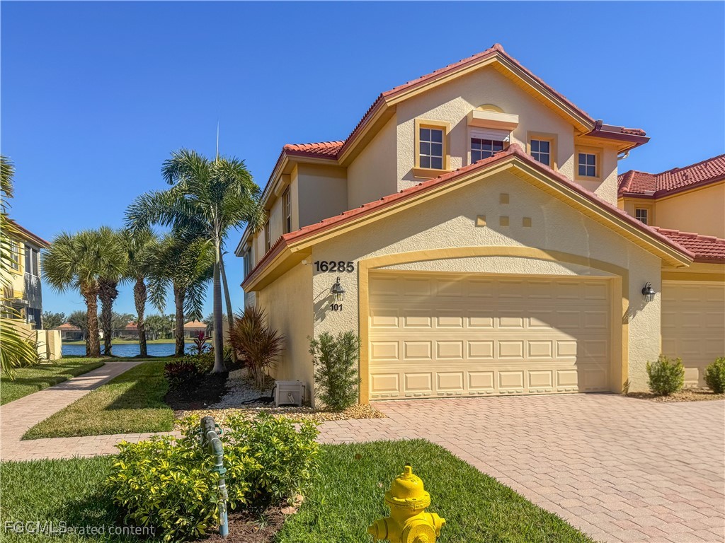 16285 Coco Hammock Way, Unit 101 Fort Myers, FL 33908 - Photo 2 of 50 a front view of a house with a yard