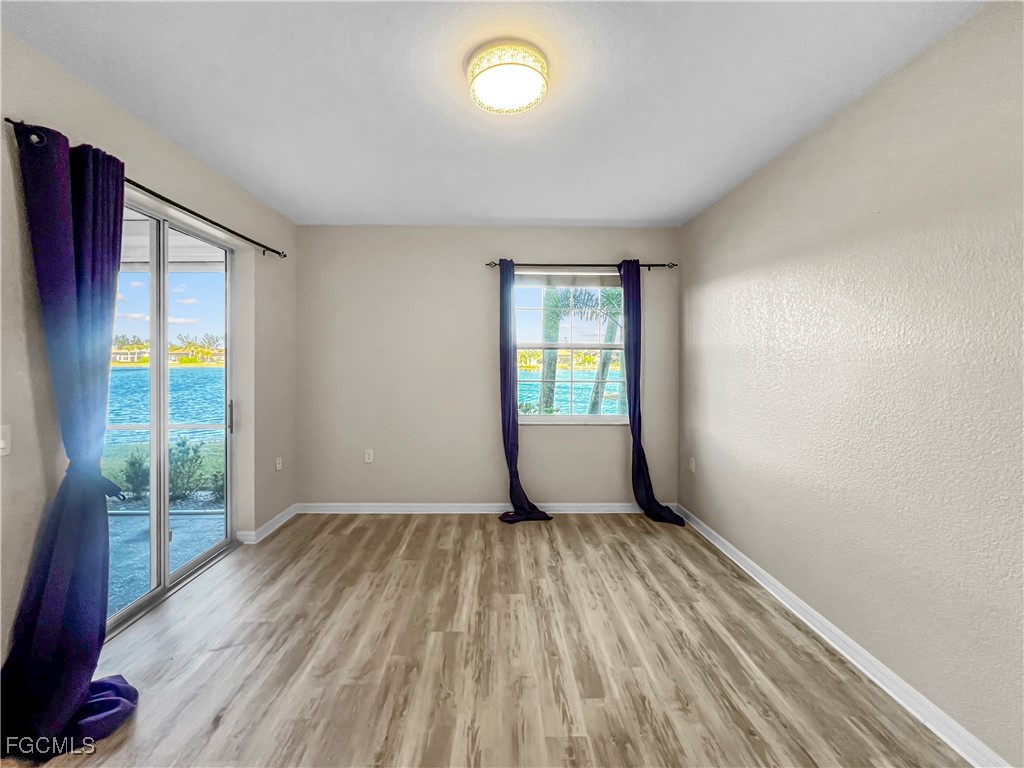 16285 Coco Hammock Way, Unit 101 Fort Myers, FL 33908 - Photo 24 of 50 wooden floor in an empty room with a window