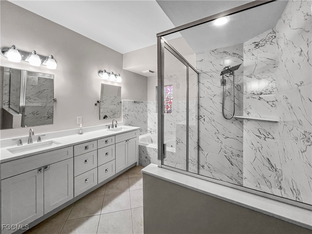16285 Coco Hammock Way, Unit 101 Fort Myers, FL 33908 - Photo 26 of 50 a bathroom with a double vanity sink mirror and shower