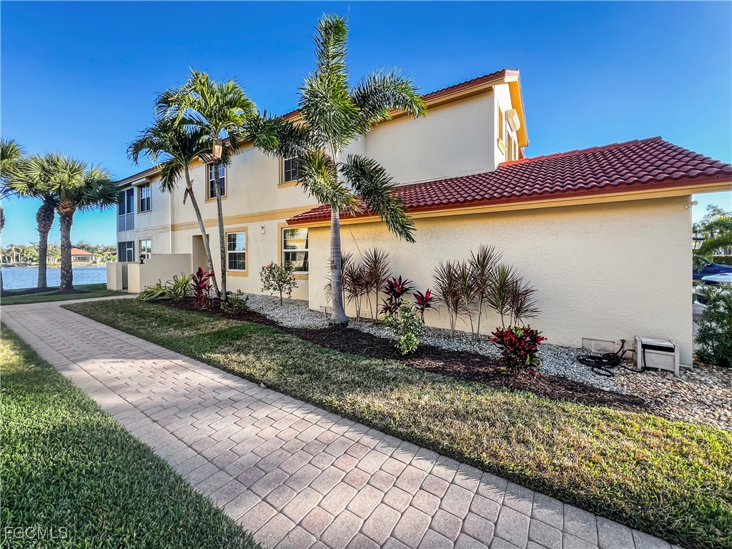 16285 Coco Hammock Way, Unit 101 Fort Myers, FL 33908 - Photo 4 of 50 a front view of a house with a yard