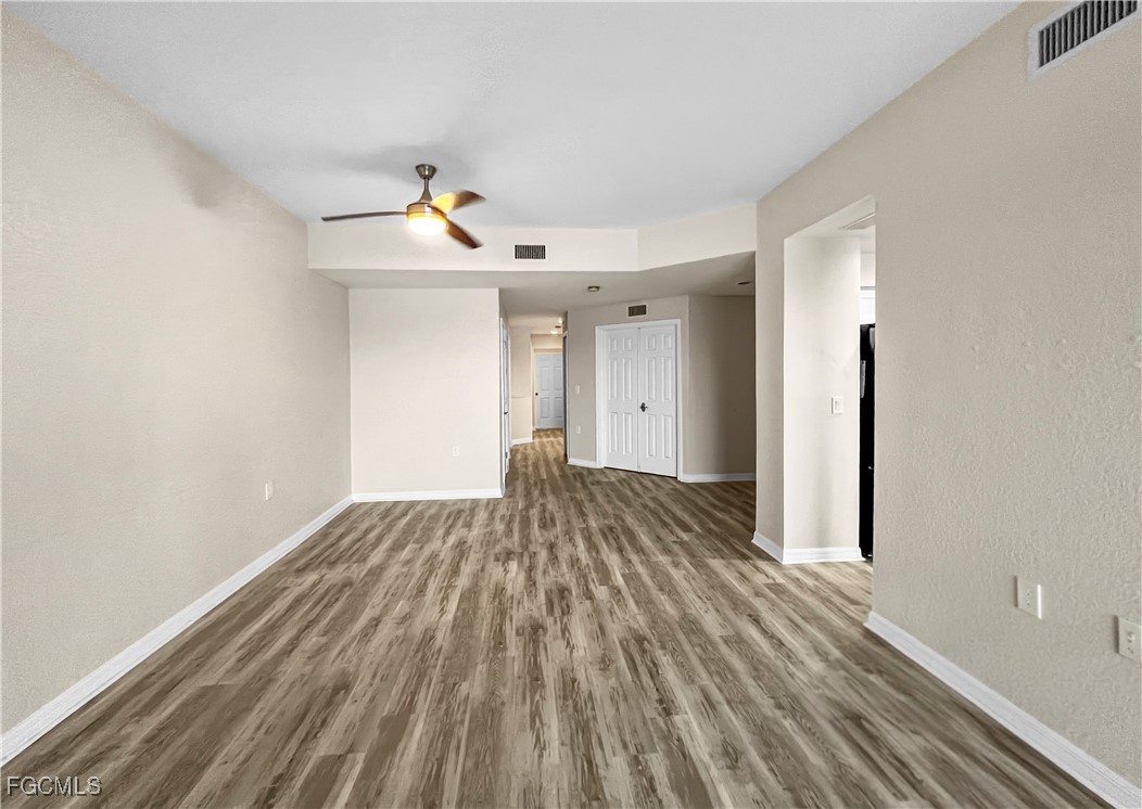 16285 Coco Hammock Way, Unit 101 Fort Myers, FL 33908 - Photo 6 of 50 a view of empty room with wooden floor and fan