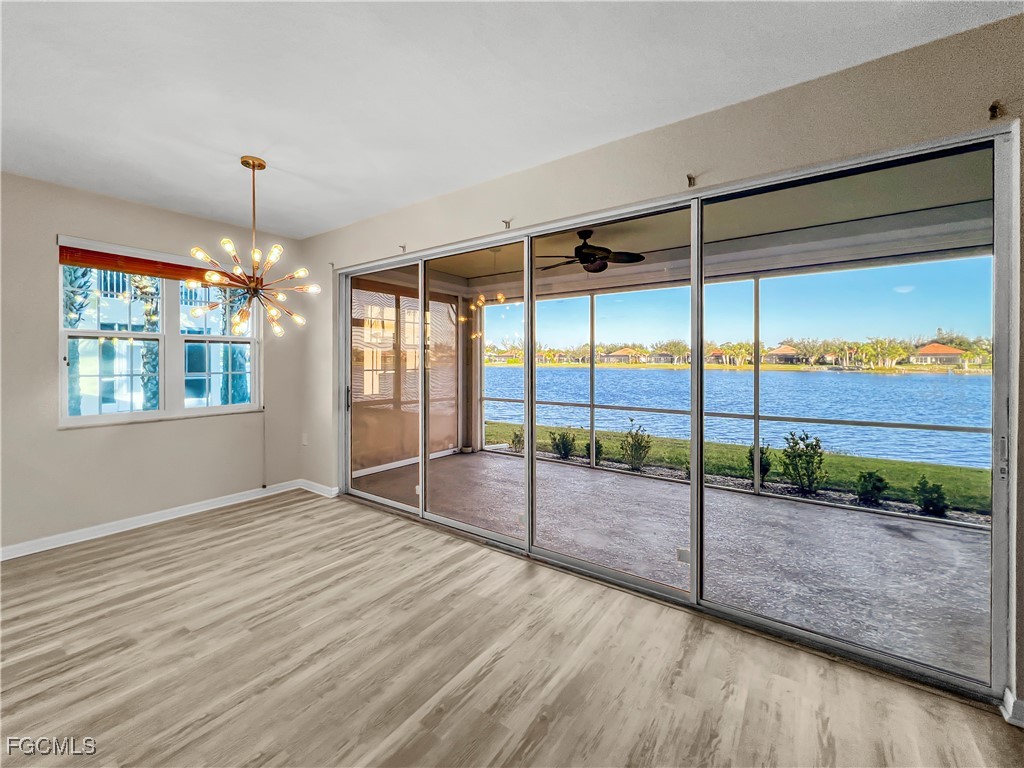 16285 Coco Hammock Way, Unit 101 Fort Myers, FL 33908 - Photo 7 of 50 a view of an empty room with window wooden floor and outdoor space