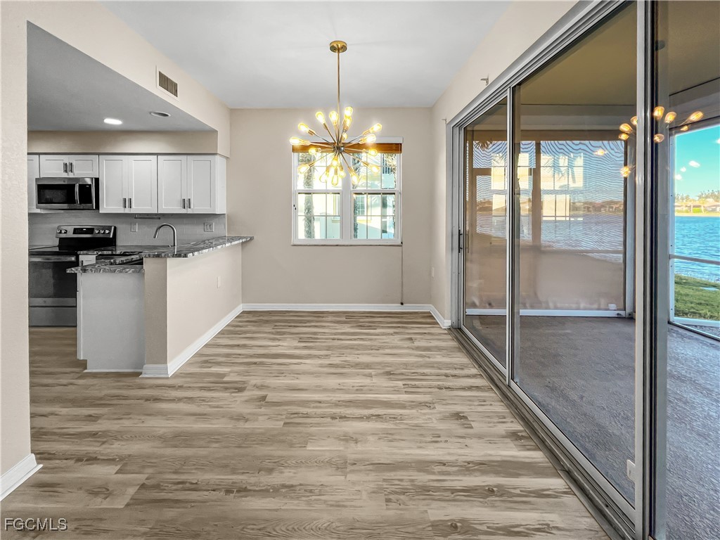 16285 Coco Hammock Way, Unit 101 Fort Myers, FL 33908 - Photo 8 of 50 a kitchen with stainless steel appliances granite countertop a refrigerator and a stove