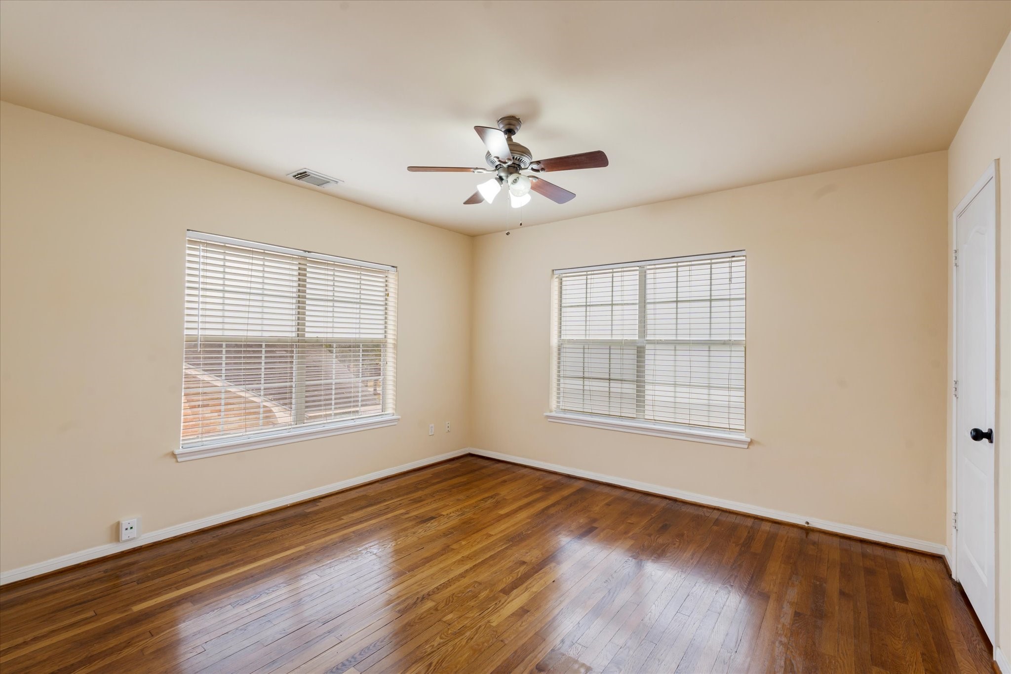 3005 Arbor Street, Unit B Houston, TX 77004 - Photo 10 of 22 an empty room with wooden floor ceiling fan and windows
