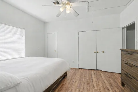 a view of a bedroom with a bed and a chandelier fan