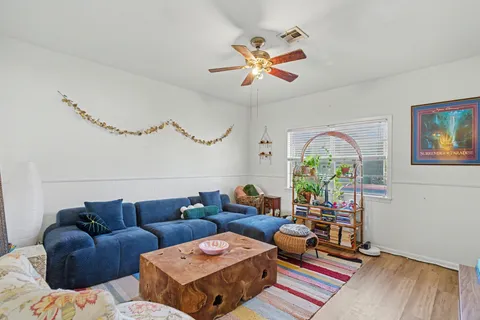 a living room with furniture a wooden floor and a chandelier