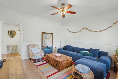 a living room with furniture and a wooden floor