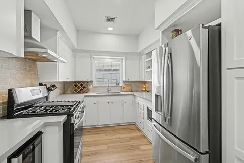 a kitchen with a refrigerator and a stove top oven