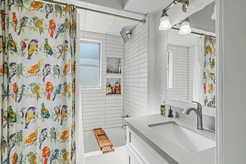 a bathroom with a sink a mirror and a shower curtain