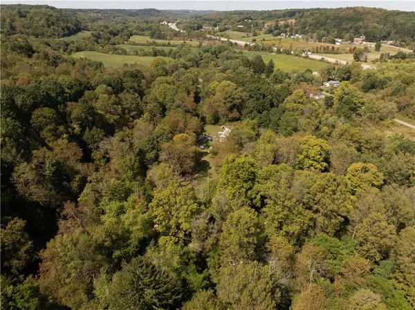 an aerial view of residential houses with outdoor space and trees