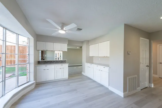 a kitchen with granite countertop a stove top oven sink and cabinets