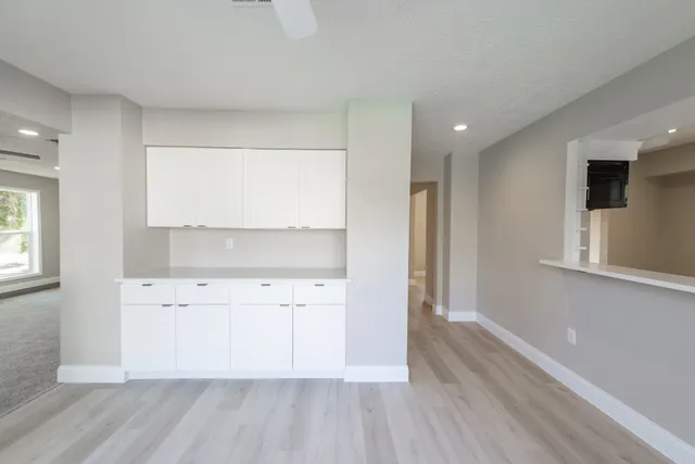 a view of cabinets a wooden floor and a window