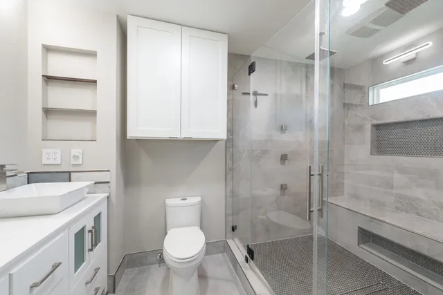 a bathroom with a granite countertop sink toilet and shower