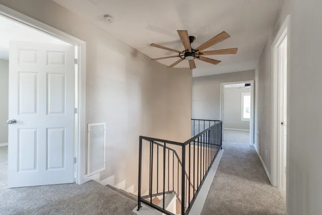a view of a hallway with a chandelier fan and entryway