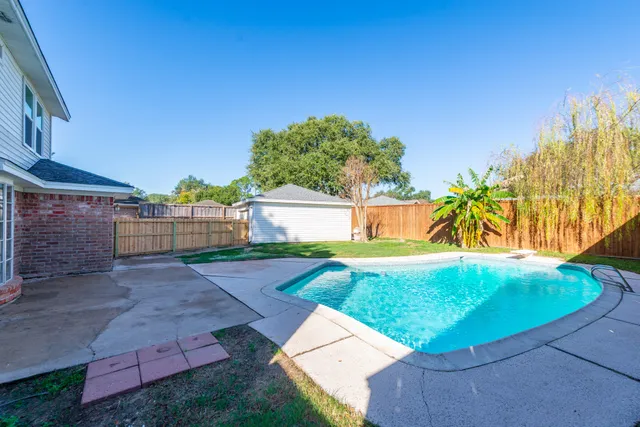 a view of a house with backyard and a tree