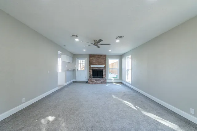an empty room with a fireplace and windows