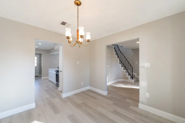a view of a hallway with wooden floor and staircase