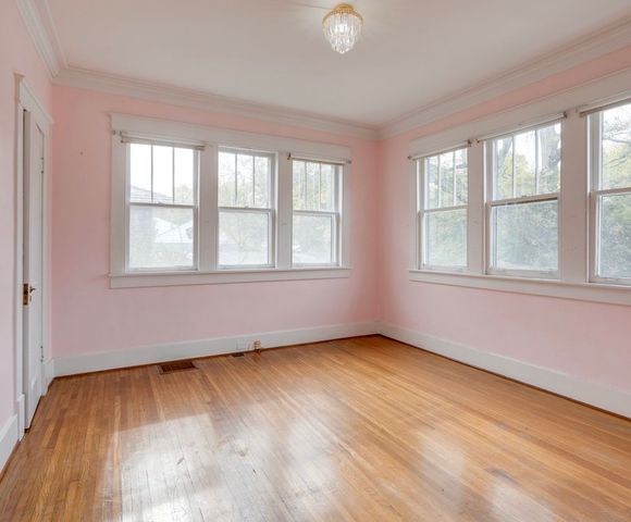a view of empty room with wooden floor