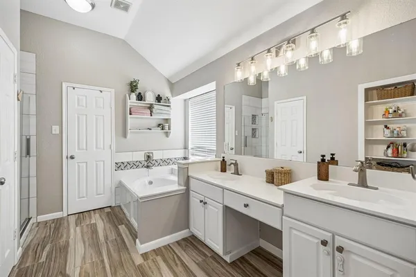 a bathroom with a sink double vanity granite tub and shower