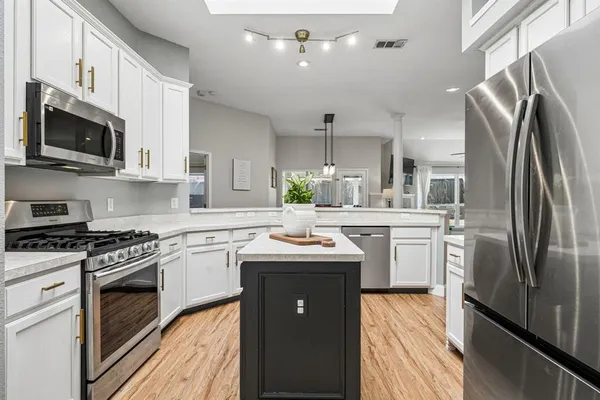 a kitchen with stainless steel appliances granite countertop a sink stove and refrigerator