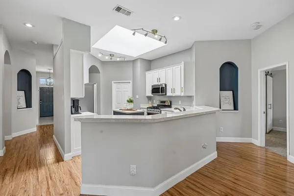 a kitchen with stainless steel appliances granite countertop a sink stove and wooden floor