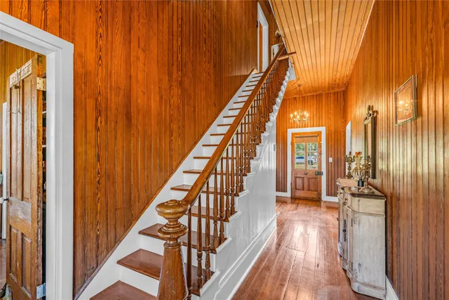 a view of a hallway with wooden floor and staircase