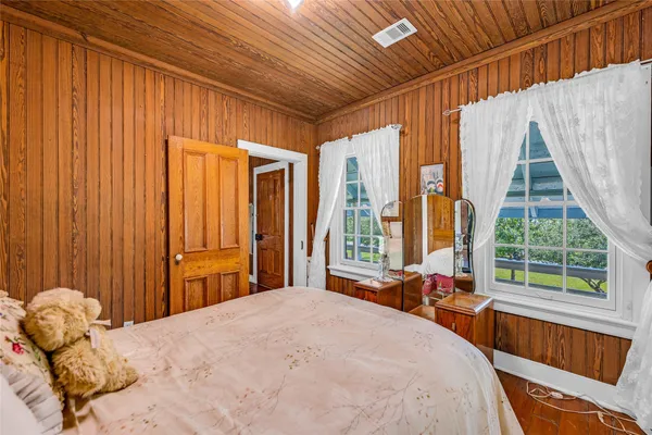 a bedroom with a bed and large windows