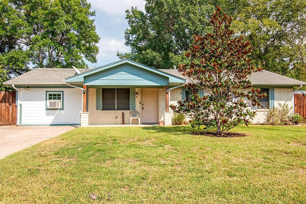 a front view of a house with a garden and trees