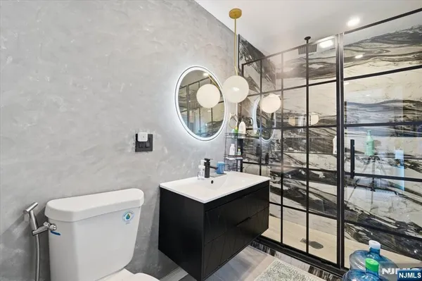 a bathroom with a granite countertop toilet sink and shower