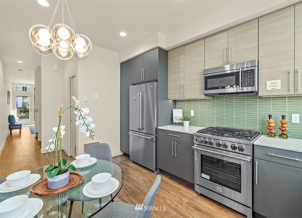 5517 4th Avenue Northwest Seattle, WA 98107 - Photo 4 of 18 a kitchen with stainless steel appliances granite countertop a stove a sink dishwasher a microwave oven with cabinets and wooden floor