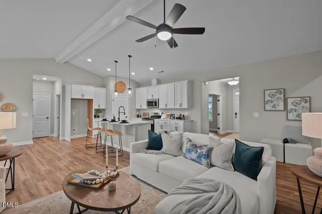a living room with furniture kitchen and a chandelier