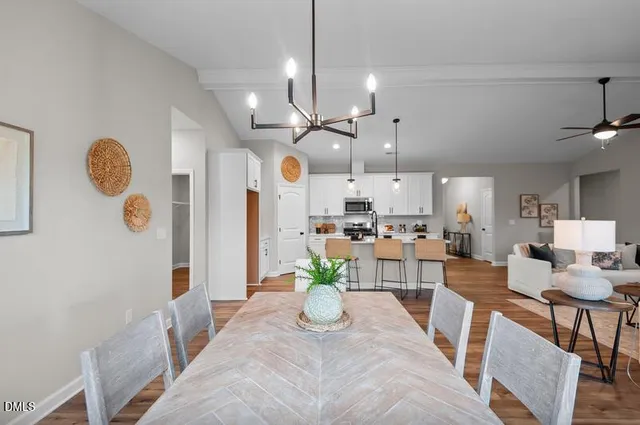 a view of a dining room and livingroom with furniture wooden floor a chandelier