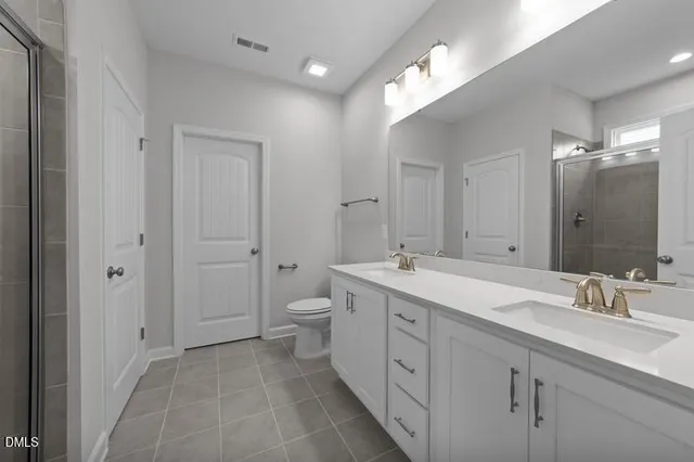 a spacious bathroom with a double vanity sink mirror and toilet
