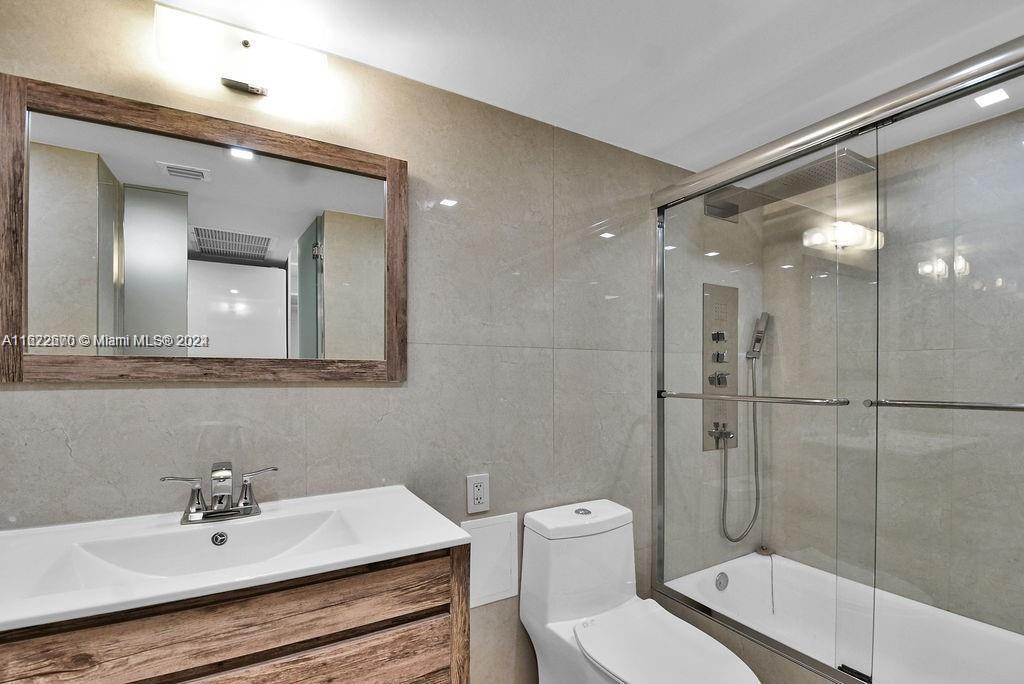 5555 Collins Avenue, Unit 5V Miami Beach, FL 33140 - Photo 11 of 46 a bathroom with a sink toilet and shower