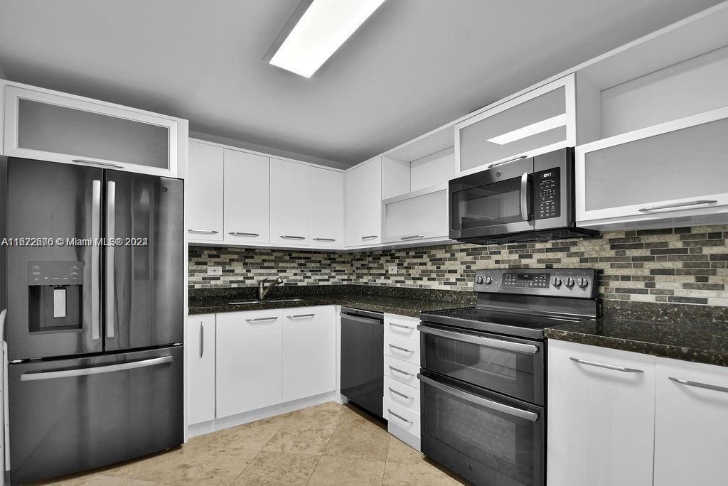 5555 Collins Avenue, Unit 5V Miami Beach, FL 33140 - Photo 12 of 46 a kitchen with stainless steel appliances and granite countertop