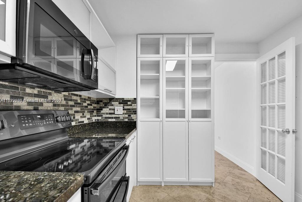 5555 Collins Avenue, Unit 5V Miami Beach, FL 33140 - Photo 13 of 46 a kitchen with a stove and a cabinet